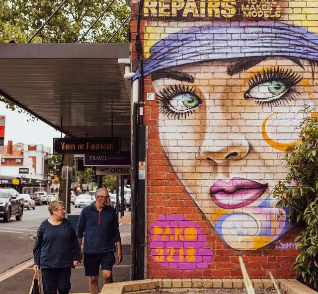 Street mural of a woman's face beside shops on Pakington Street, Geelong